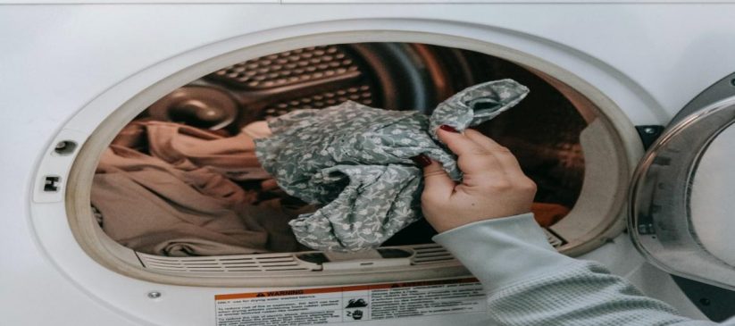 Clothes being taken out of the dryer by a woman’s hand