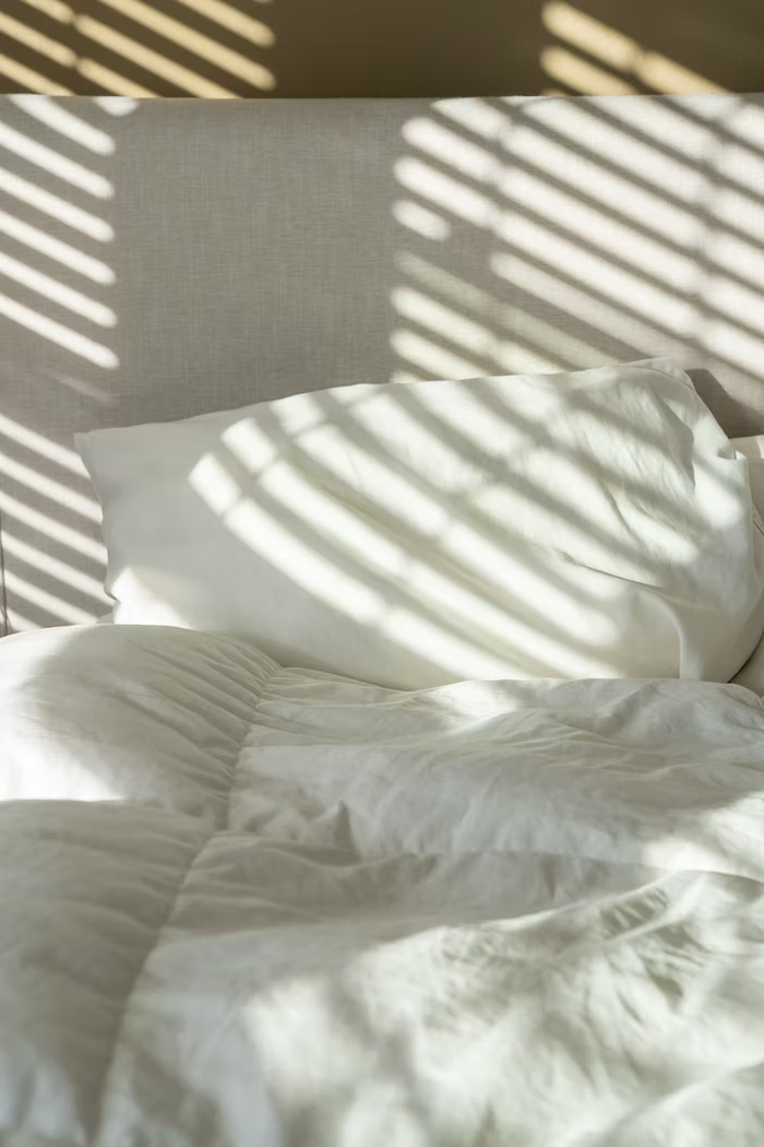 A white linen bed sheet and bed covers