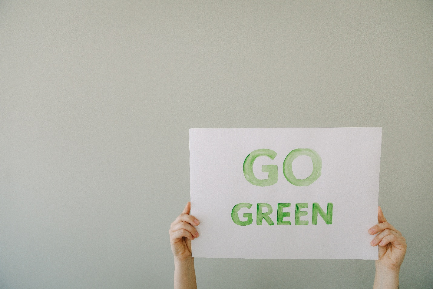  A pair of hands holding a “go green” sign