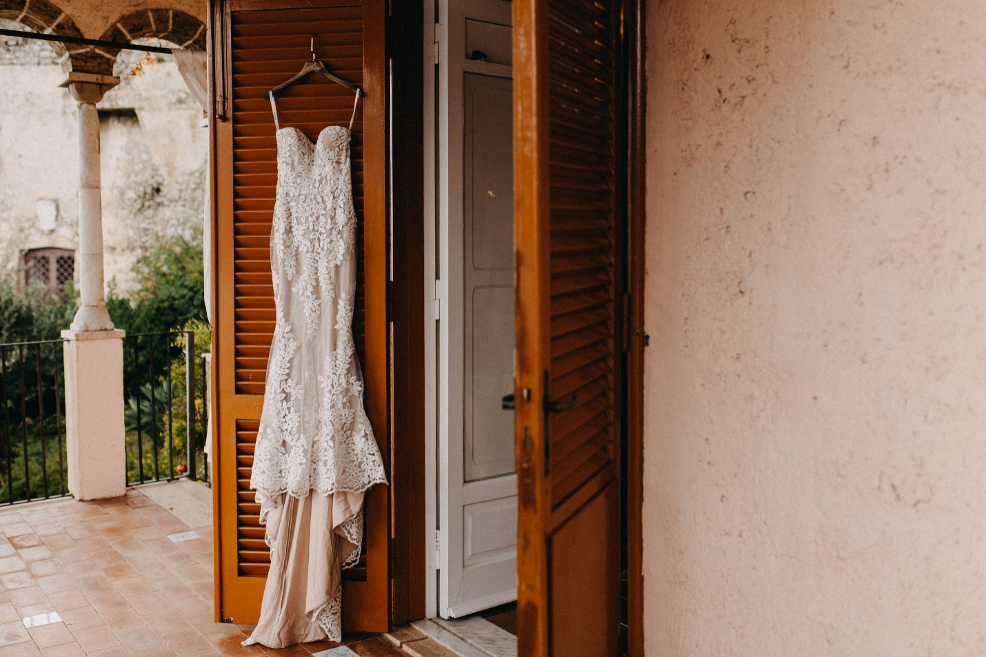 A wedding dress hanging from a wooden door
