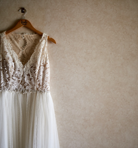 A lace wedding dress on a wooden hanger