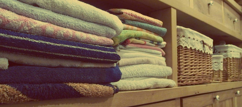 A stack of clean towels on a rack after professional laundry wash and fold
