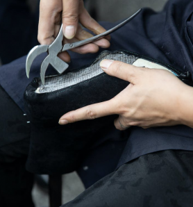 A person making leather shoes